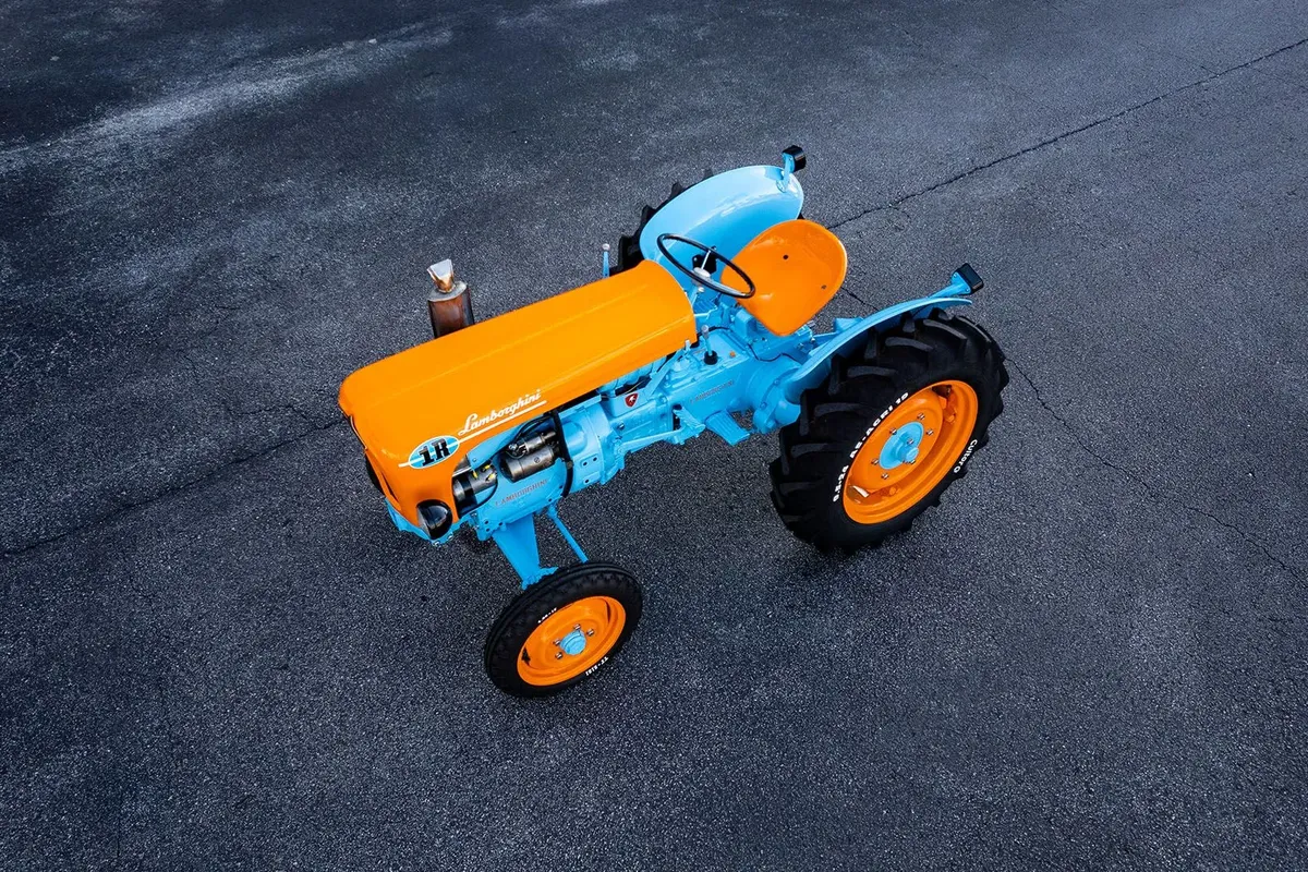 A restored 1966 Lamborghini 1R tractor parked on grass in the countryside