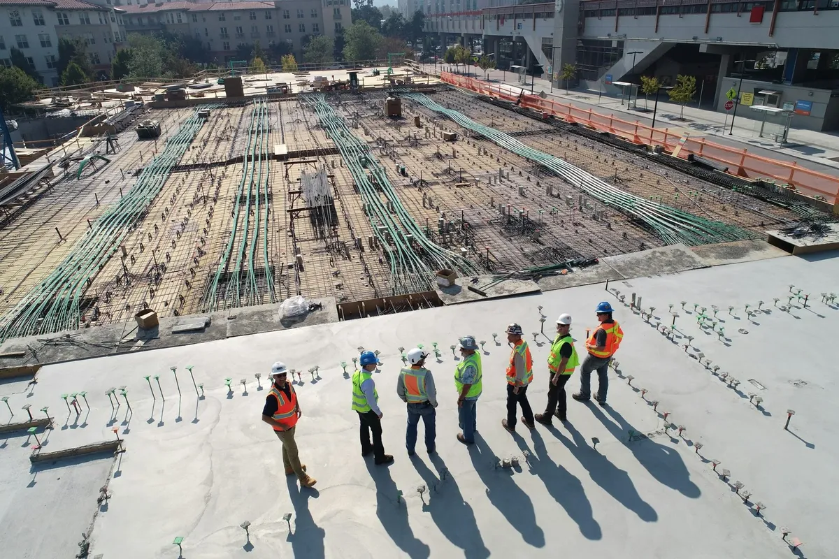 A team in high visibility jackets and hard hats on a building site deck under construction
